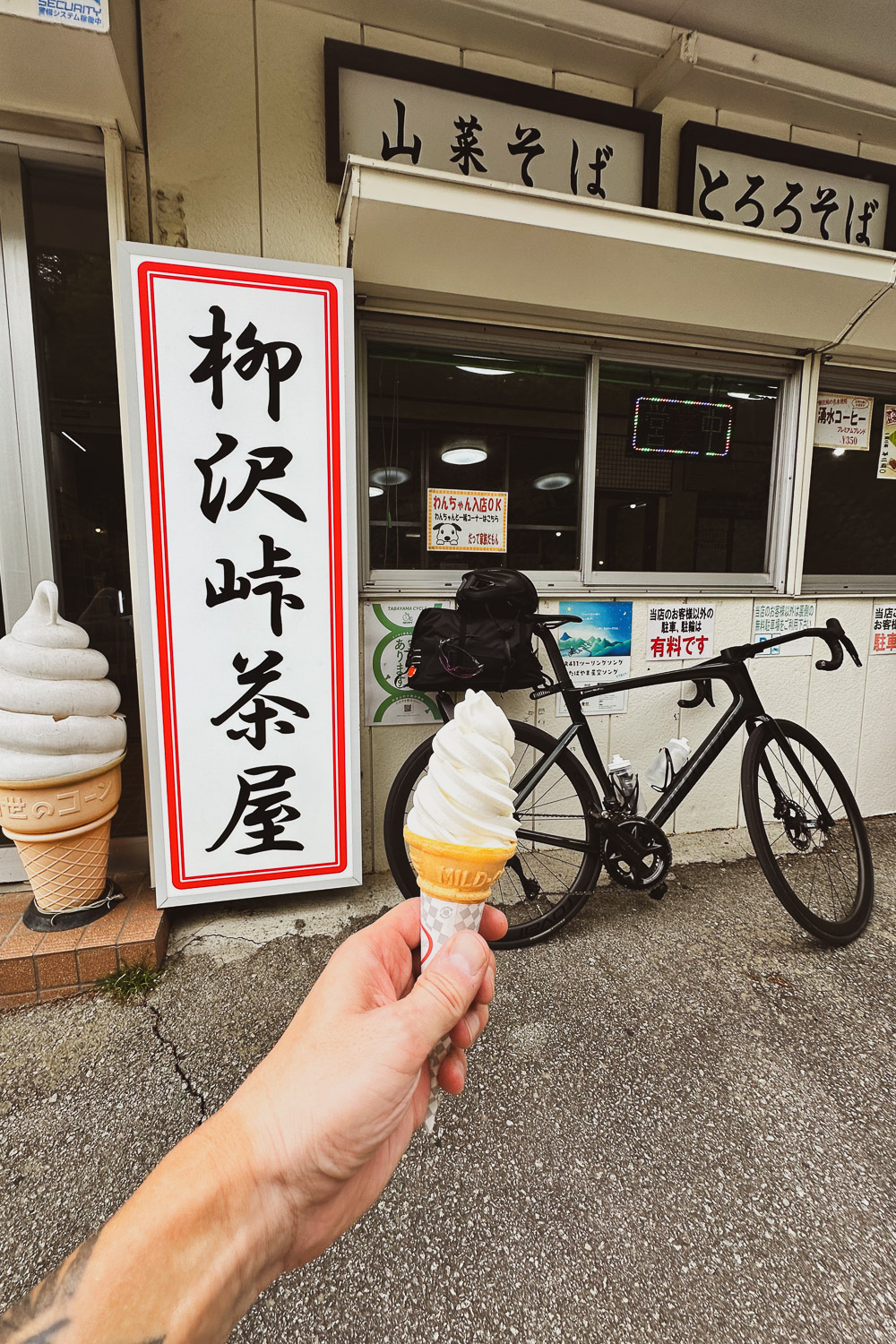 Eating a soft served at the top of Yanagisawa pass after cycling uphill. 